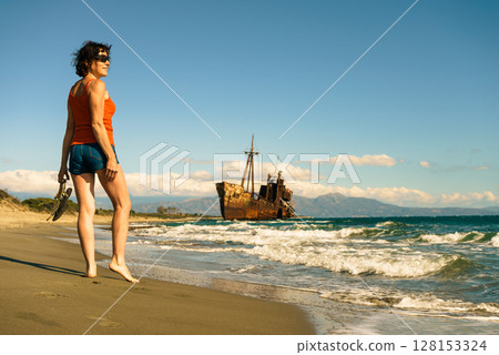 Tourist woman on beach enjoying vacation 128153324
