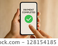 Hand holding smartphone with Payment Completed 128154185