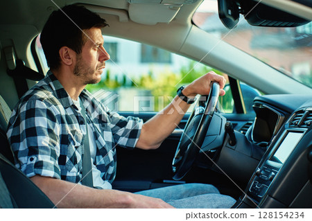Focused man driving car, interior view Focused man driving car, interior view 128154234