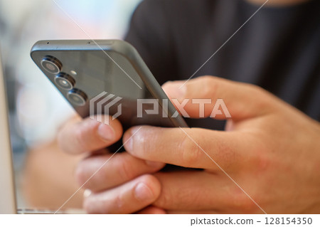 Man using smartphone at home Man using smartphone at home 128154350