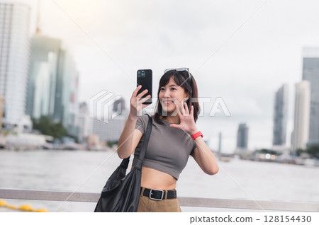 Happy solo southeast asian woman teenager blogger on world travel tourism in Bangkok Thailand express joy local cultural experience an explorer uses smartphone by boat on Chao Phraya river Asia Happy solo southeast asian woman teenager blogger on world travel tourism in Bangkok Thailand express joy local cultural experience an explorer uses smartphone by boat on Chao Phraya river Asia 128154430