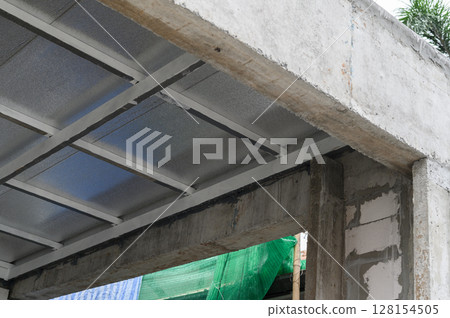 Architectural detail shows robust concrete beam supporting roof made of durable metal sheet material and lightweight pu foam insulation providing weather protection during building construction 128154505