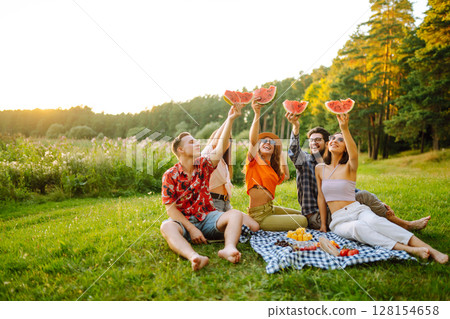 Group of people gathered in garden for picnic. Friends have fun and drink beer. Picnic, friendship. 128154658