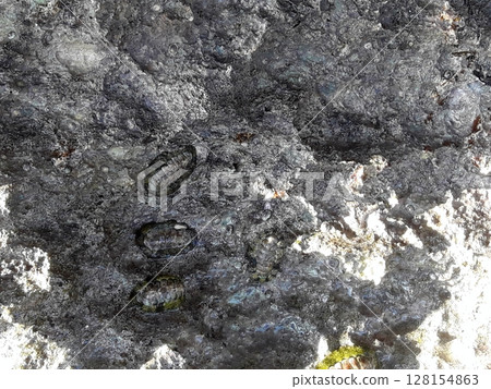 Close Up of Sandy Cliff Face with Rough Textured Surface Under Clear Blue Sky Close Up of Sandy Cliff Face with Rough Textured Surface Under Clear Blue Sky 128154863