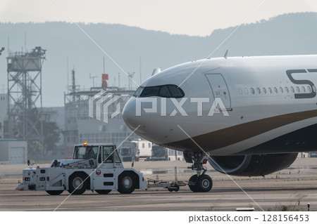 黃昏時分的仙台機場，牽引拖拉機和飛機，宮城縣名取市 128156453