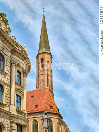 Historic Gothic Church Tower of Heilig-Geist in Munich: Red Tiled Roof and Medieval Brick Architecture Framed by Ornate Facade and Blue Sky in the Bavarian Old Town Historic Gothic Church Tower of Heilig-Geist in Munich: Red Tiled Roof and Medieval Brick Architecture Framed by Ornate Facade and Blue Sky in the Bavarian Old Town 128156734