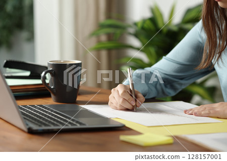Office worker hands writing on document Office worker hands writing on document 128157001