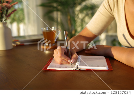 Woman hand writing with a pen in agenda Woman hand writing with a pen in agenda 128157024