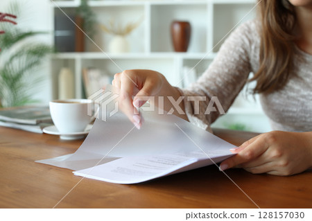 Woman hands putting paper sheet in transparent plastic file wallet 128157030