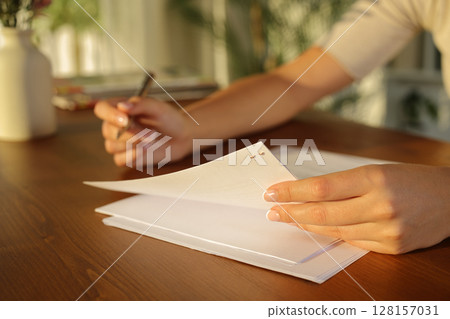 Woman hands reading document at home 128157031