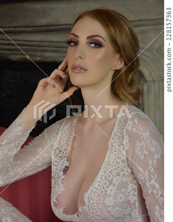 Beautiful, redheaded girl dressed in lace, posing in rooms of an old Manor House 128157363