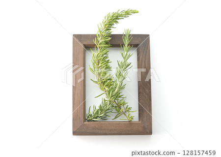 Wooden picture frame and rosemary leaves photographed on white background 128157459