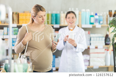 Pregnant woman choosing cream with help of pharmacist Pregnant woman choosing cream with help of pharmacist 128157612