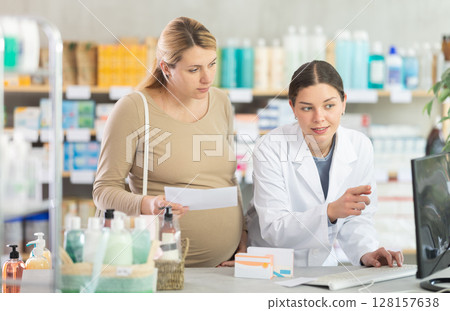 Pharmacist looking for prescription on computer for pregnant woman 128157638
