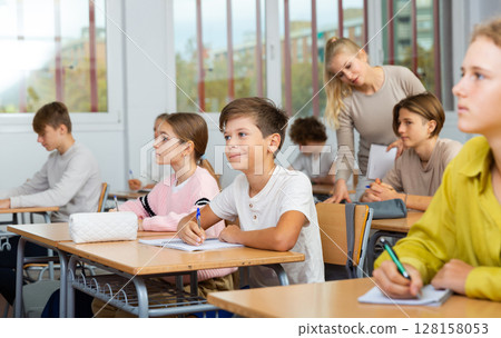 Schoolboy posing in classroom during lesson 128158053