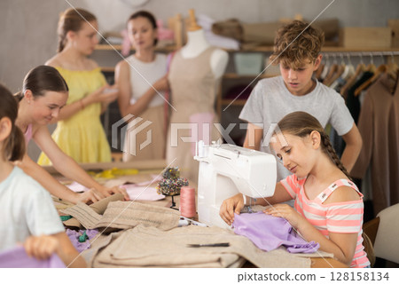 Preteen girl sewing on machine during hands-on class for school children 128158134
