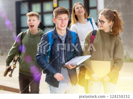 Smiling teenagers walking outside after lessons 128158152