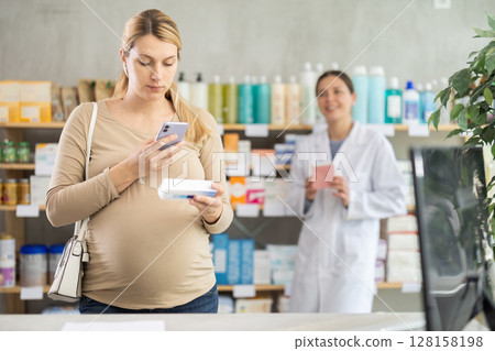 Pregnant woman buyer scans pills qr code with woman pharmacist 128158198