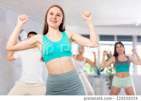 Teenage girl practicing hip-hop movements during group dance class Teenage girl practicing hip-hop movements during group dance class 128158324