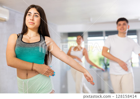 Girl teen perform choreographic exercise and teach energetic mobile social dance vogue with friends Girl teen perform choreographic exercise and teach energetic mobile social dance vogue with friends 128158414