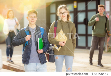 Smiling teenagers walking outside after lessons Smiling teenagers walking outside after lessons 128158437