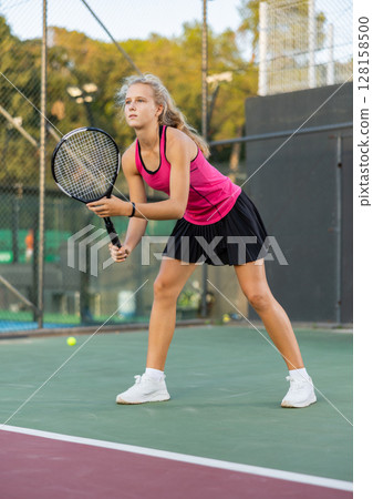Portrait of focused woman playing on court, ready to hit ball. Active lifestyle concept Portrait of focused woman playing on court, ready to hit ball. Active lifestyle concept 128158500