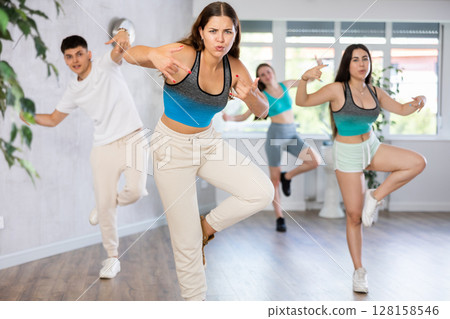 Group of teenagers dancing modern dance in ballroom Group of teenagers dancing modern dance in ballroom 128158546