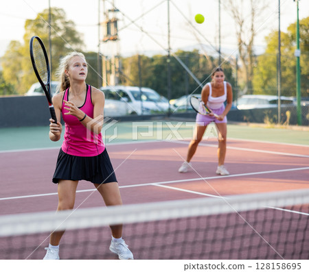 Girl playing tennis match during training on court Girl playing tennis match during training on court 128158695