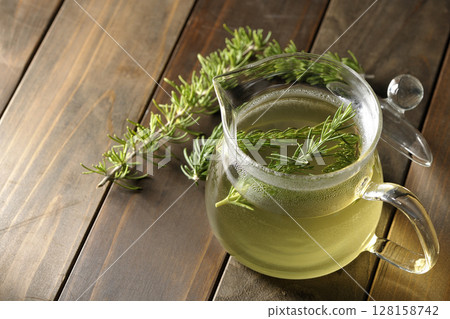 Teapot with rosemary leaves and herbal tea Teapot with rosemary leaves and herbal tea 128158742
