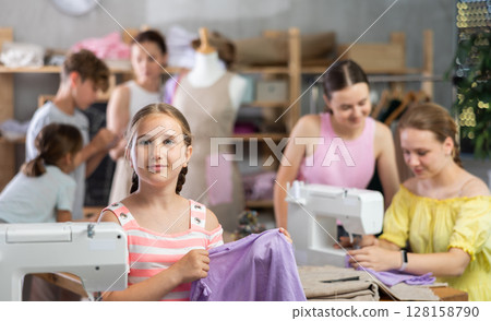 Smiling preteen schoolgirl in kids sewing workshop 128158790