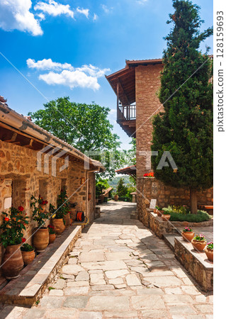 Peaceful monastery stone courtyard with flower pots in Meteora Greece 128159693