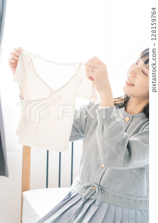 孕婦在臥室準備嬰兒衣服 128159764