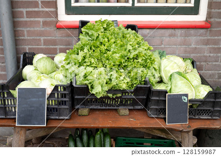 Fresh green lettuce and cabbage displayed outside a market stall 128159987