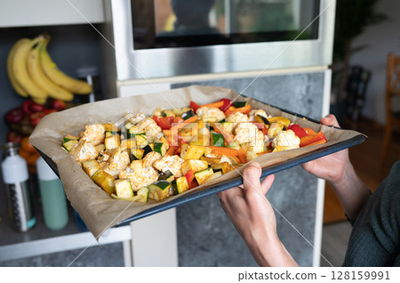 Freshly baked tray of colorful roasted vegetables in modern kitchen Freshly baked tray of colorful roasted vegetables in modern kitchen 128159991
