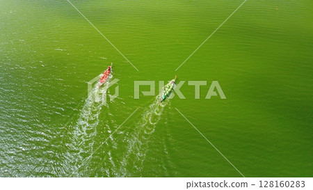 Aerial view of a rowing boat competition, one of which erroneously changes its trajectory. Rowboats with teams of rude people rushing along the water surface to the finish line. Aerial view of a rowing boat competition, one of which erroneously changes its trajectory. Rowboats with teams of rude people rushing along the water surface to the finish line. 128160283
