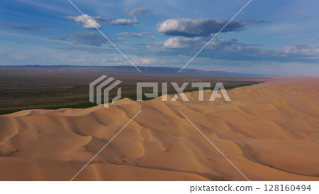 Aerial view of sand dunes in desert at sunset 128160494