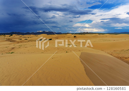 Sand dunes with storm clouds at sunset Sand dunes with storm clouds at sunset 128160581