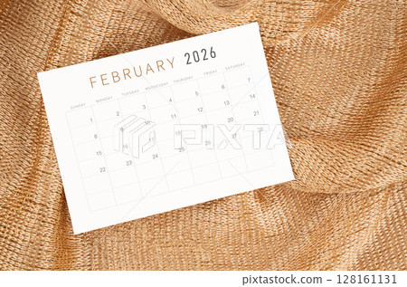 February 2026 calendar card on golden color textile background. February 2026 calendar card on golden color textile background. 128161131