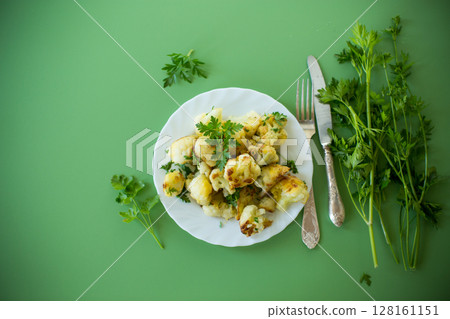Top view of crispy cauliflower with parsley on a green background 128161151