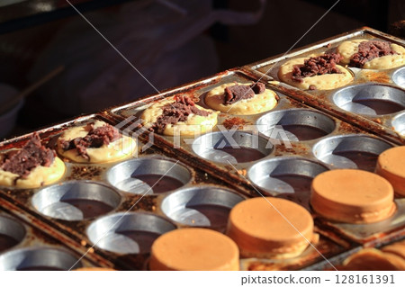 Obanyaki filled with red bean paste being baked Obanyaki filled with red bean paste being baked 128161391