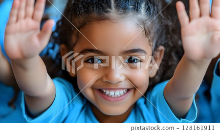 Joyful Child with Braids Raises Hands in Close Up Joyful Child with Braids Raises Hands in Close Up 128161911