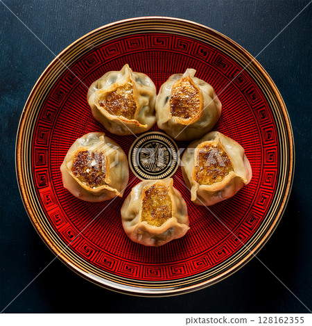 Elegant Dumplings on Vibrant Decorative Plate 128162355