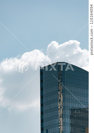 Tall glass building with sky and cloud background Tall glass building with sky and cloud background 128164094