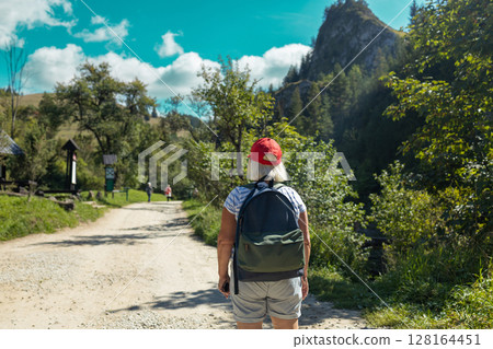 Senior Woman Hiking Alone on Mountain Trail in Nature 128164451