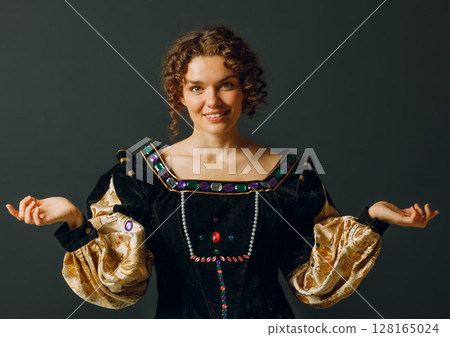 Portrait of a young aristocratic woman dressed in a medieval dress on dark background 128165024