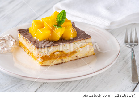 Chocolate-Glazed Mango Cheesecake Square Topped With Mango Cubes and Mint Leaf Chocolate-Glazed Mango Cheesecake Square Topped With Mango Cubes and Mint Leaf 128165184