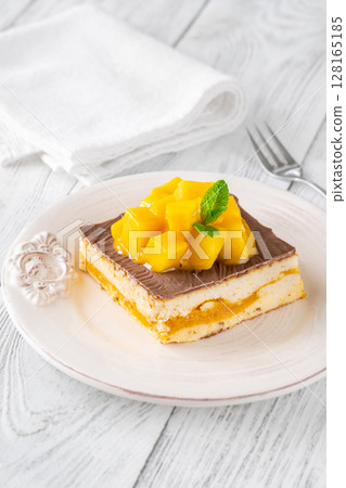 Chocolate-Glazed Mango Cheesecake Square Topped With Mango Cubes and Mint Leaf 128165185