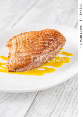 Whole Crispy Duck Breast on Mustard Lemon Honey Sauce in White Plate Whole Crispy Duck Breast on Mustard Lemon Honey Sauce in White Plate 128165188