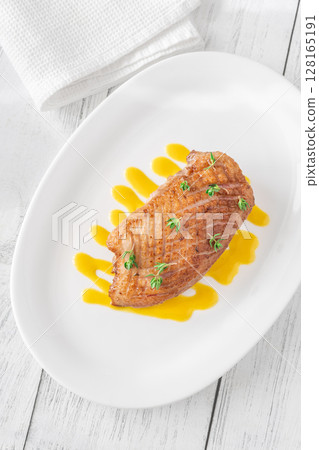Whole Crispy Duck Breast on Mustard Lemon Honey Sauce in White Plate Whole Crispy Duck Breast on Mustard Lemon Honey Sauce in White Plate 128165191