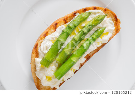 Grilled sandwich with white bread, stracciatella cheese, and green asparagus 128165212